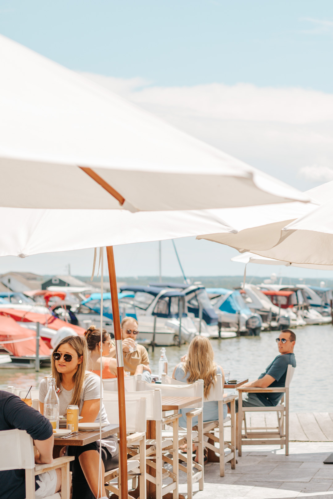 Guests enjoying refreshing cocktails and delicious menu items on the lakefront in the sunshine